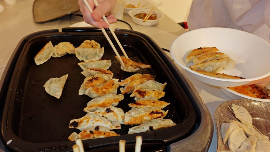パリッと焼けた餃子を取り分けています。1ついただきましたらとても美味しかったです。